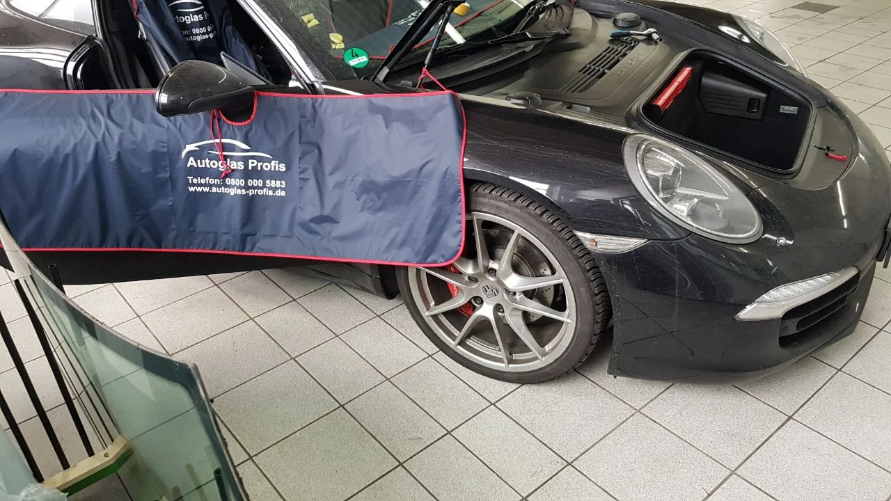 Vorbereitung am Fahrzeug mit Schutzabdeckung und ausgebauter Scheibe.
